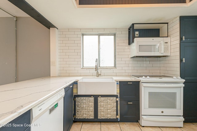 kitchen with white appliances, light stone counters, light tile patterned floors, decorative backsplash, and sink