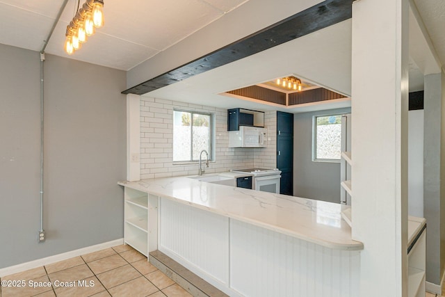 kitchen featuring white appliances, light tile patterned floors, decorative backsplash, white cabinets, and sink