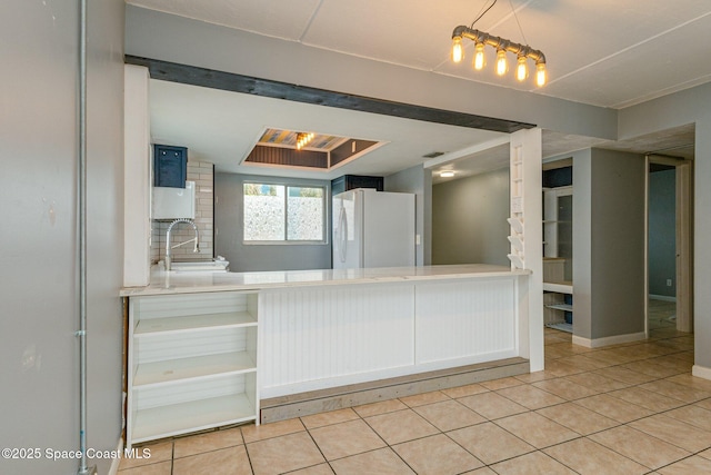 kitchen featuring white refrigerator, sink, and light tile patterned floors