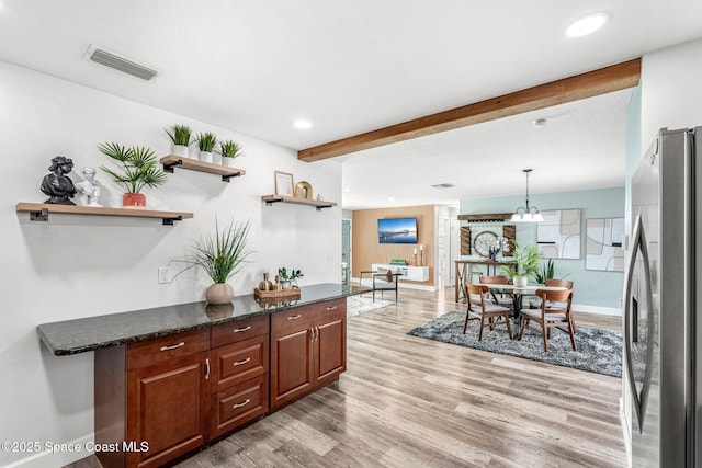 kitchen with pendant lighting, stainless steel fridge, an inviting chandelier, light hardwood / wood-style floors, and beamed ceiling