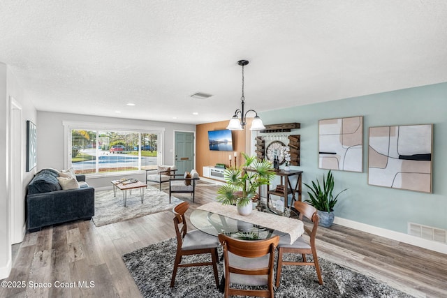 dining room featuring hardwood / wood-style flooring and a textured ceiling