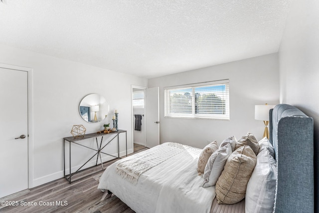 bedroom with hardwood / wood-style floors and a textured ceiling