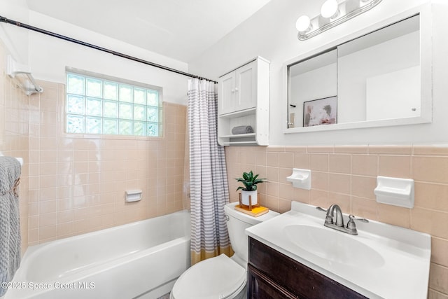 full bathroom with vanity, tile walls, shower / tub combo, and toilet