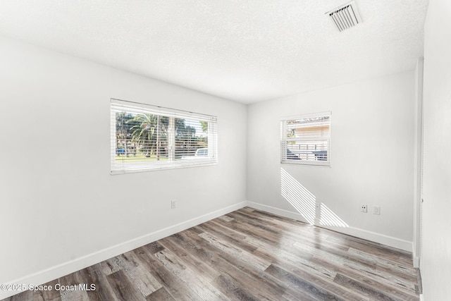 unfurnished room featuring hardwood / wood-style floors and a textured ceiling