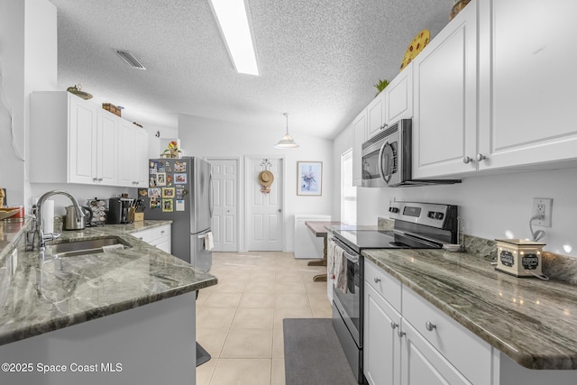 kitchen with light tile patterned floors, stainless steel appliances, white cabinetry, and sink