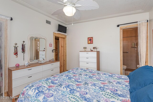 bedroom with a textured ceiling, ensuite bath, ceiling fan, and ornamental molding