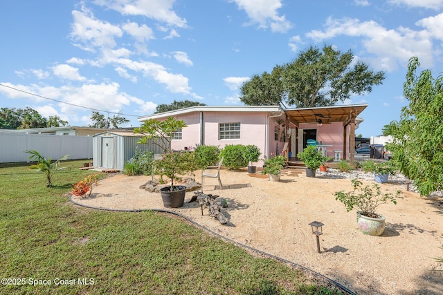 rear view of property featuring a yard and a shed