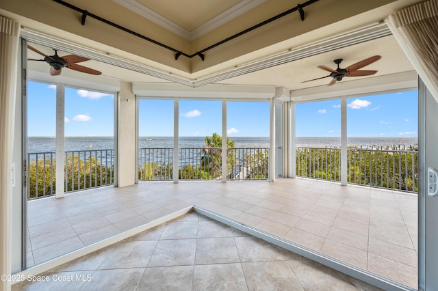 unfurnished sunroom featuring a water view and a ceiling fan