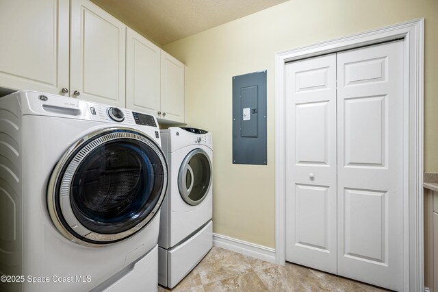 clothes washing area with electric panel, cabinet space, baseboards, and separate washer and dryer