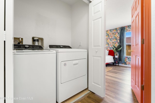 clothes washing area featuring washing machine and dryer and light hardwood / wood-style floors