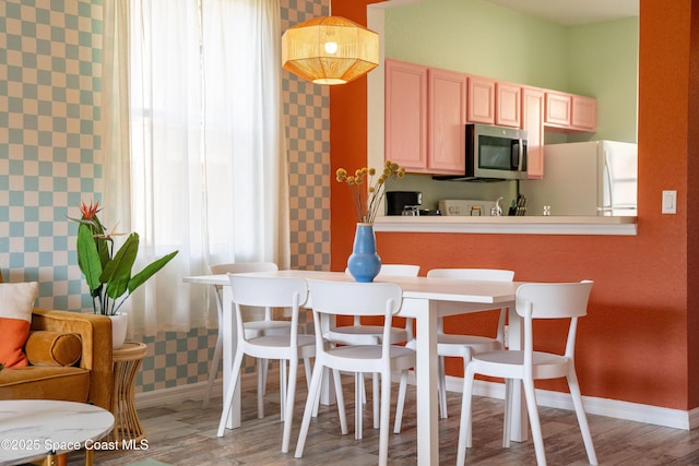 kitchen featuring light brown cabinets, white refrigerator, a wealth of natural light, and wood-type flooring