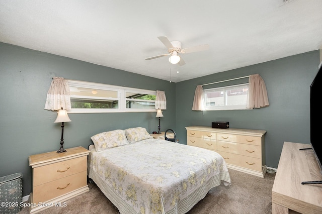 carpeted bedroom with multiple windows and ceiling fan