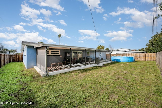 back of house featuring a yard and a sunroom