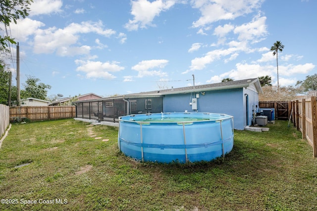 rear view of property featuring a yard, a fenced in pool, and central AC unit