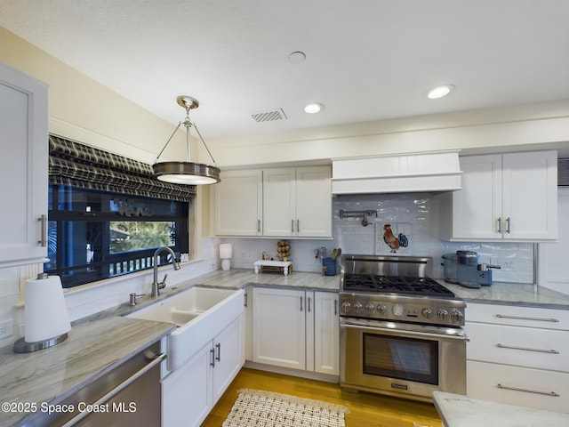 kitchen with white cabinets, tasteful backsplash, decorative light fixtures, light stone counters, and stainless steel appliances