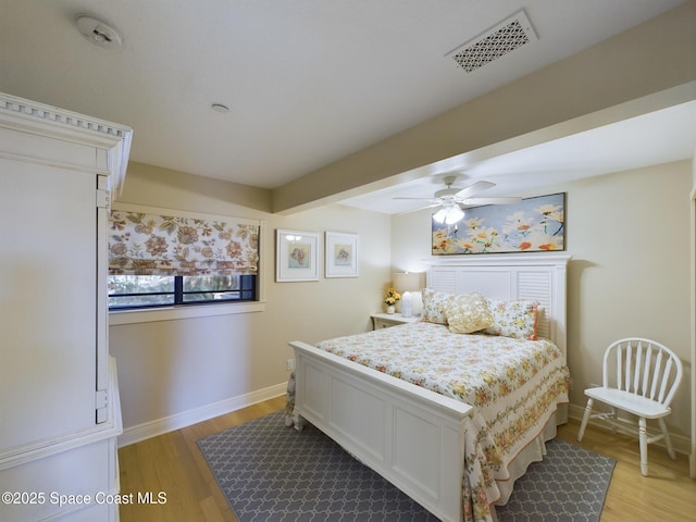 bedroom with beamed ceiling, light wood-type flooring, and ceiling fan