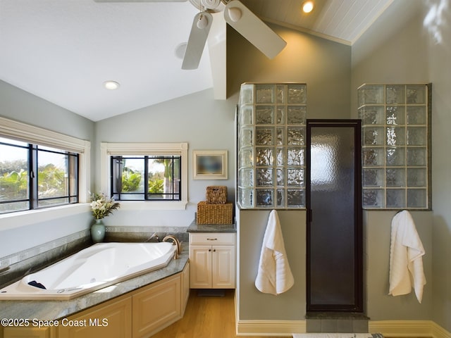 bathroom featuring ceiling fan, wood-type flooring, lofted ceiling, and plus walk in shower