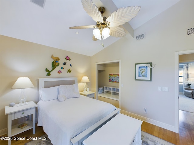 bedroom with ceiling fan, hardwood / wood-style floors, and vaulted ceiling