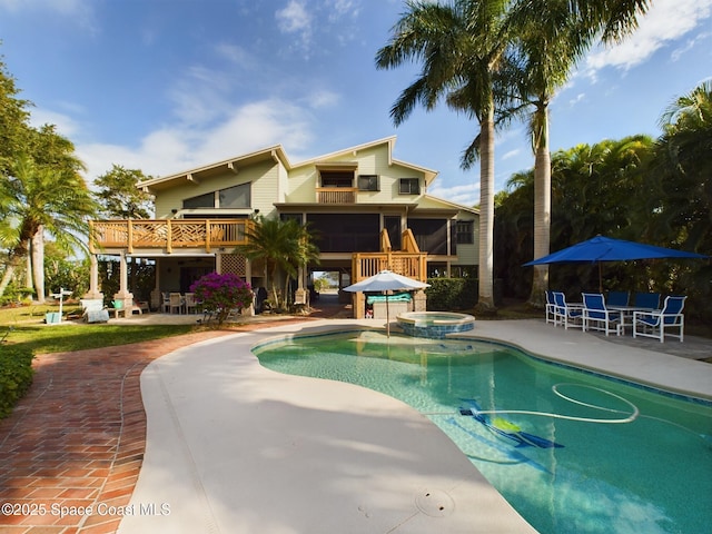 view of pool with a sunroom, a deck, an in ground hot tub, and a patio