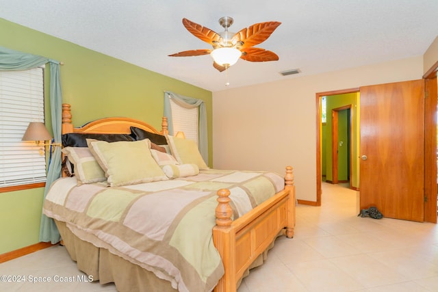 bedroom with ceiling fan and a textured ceiling