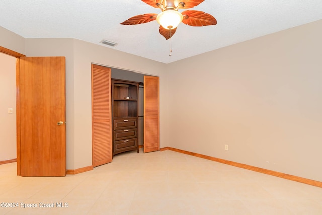 unfurnished bedroom featuring a textured ceiling, a closet, and ceiling fan