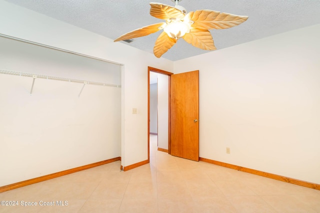 unfurnished bedroom featuring ceiling fan, a closet, and a textured ceiling