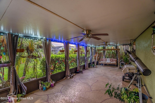 unfurnished sunroom with a wealth of natural light and ceiling fan