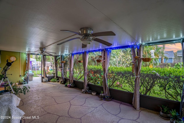 unfurnished sunroom with ceiling fan