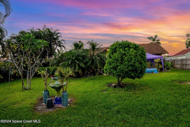 yard at dusk with a gazebo