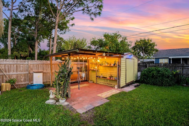 outdoor structure at dusk featuring a lawn