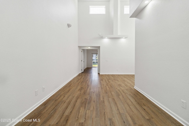 interior space with hardwood / wood-style floors, plenty of natural light, and a high ceiling