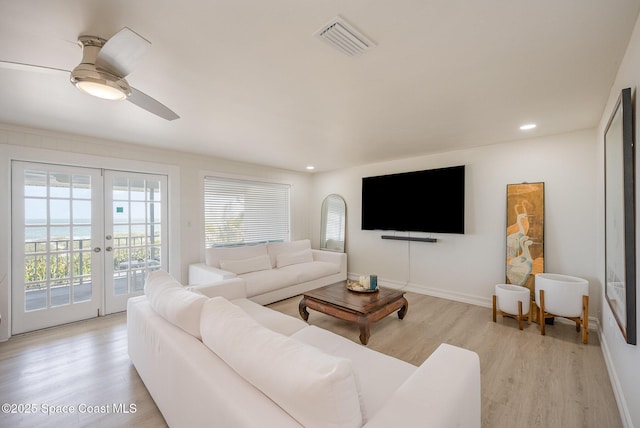 living room featuring french doors, ceiling fan, and light wood-type flooring