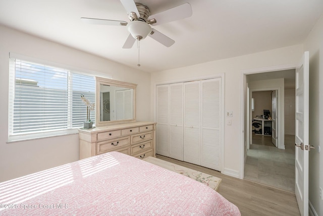 bedroom with ceiling fan, light hardwood / wood-style floors, and a closet