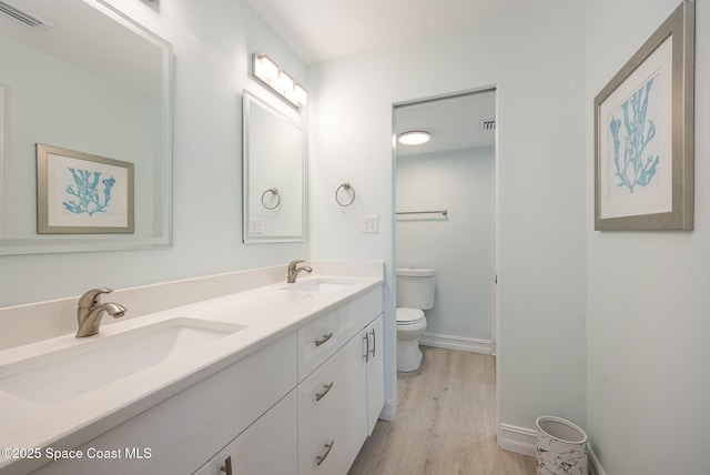 bathroom with vanity, toilet, and hardwood / wood-style floors