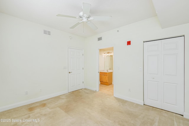 unfurnished bedroom featuring ceiling fan, light colored carpet, a closet, and sink