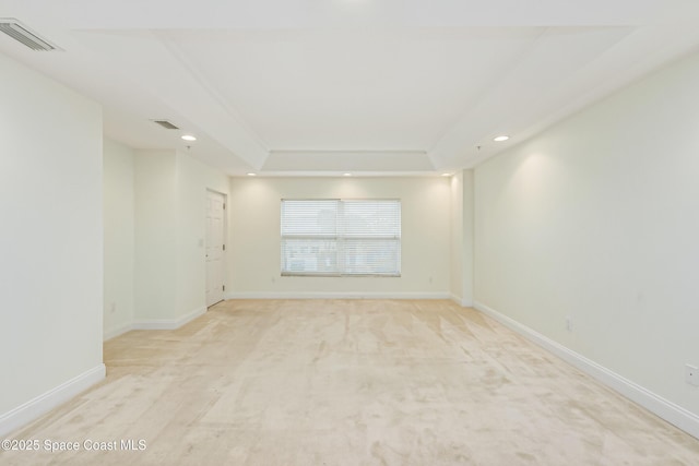 carpeted empty room featuring a raised ceiling