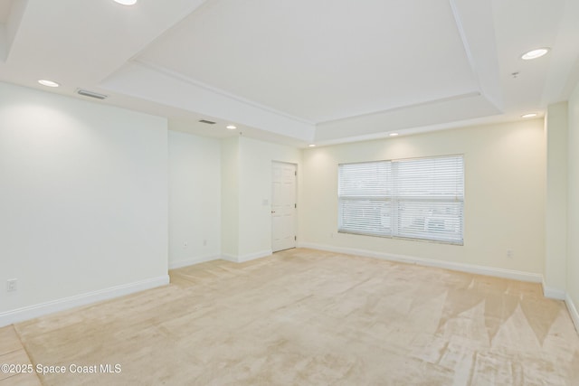 carpeted empty room featuring a tray ceiling