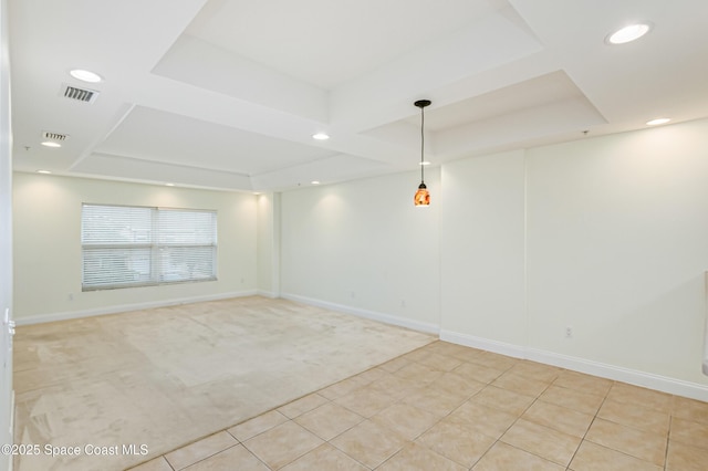 tiled spare room with a raised ceiling