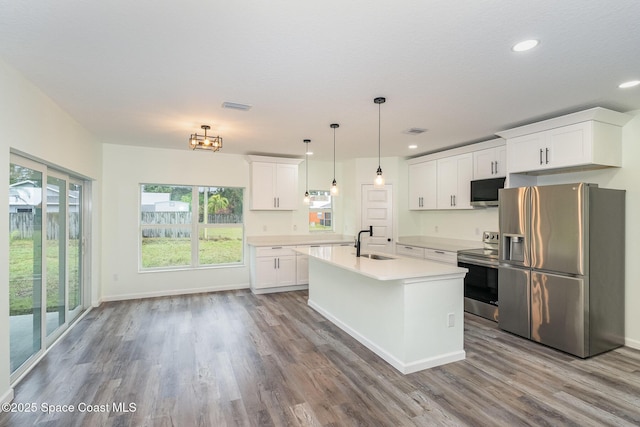 kitchen featuring sink, decorative light fixtures, stainless steel appliances, and white cabinets