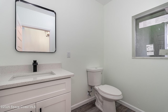 bathroom featuring vanity, wood-type flooring, and toilet