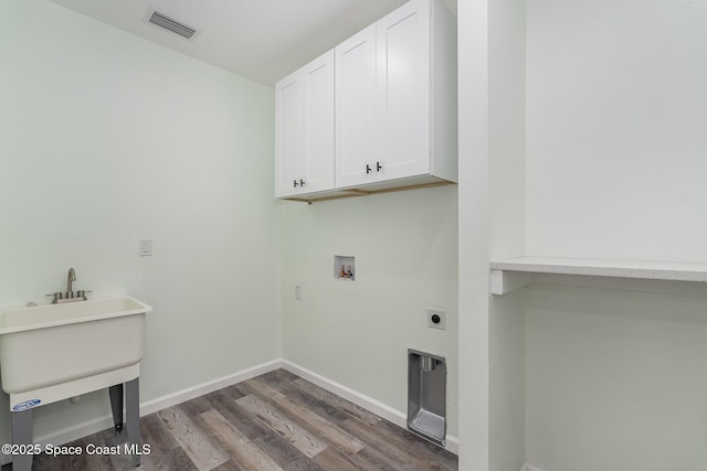 washroom with washer hookup, dark hardwood / wood-style flooring, cabinets, and hookup for an electric dryer