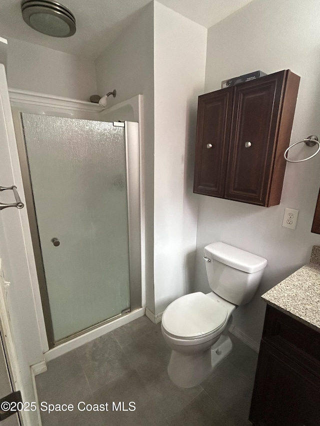 bathroom featuring vanity, toilet, and a shower with shower door