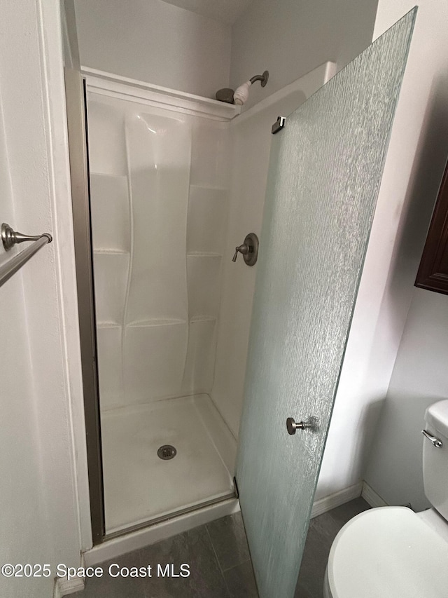 bathroom featuring toilet, tile patterned flooring, and walk in shower