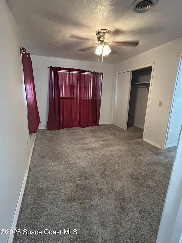 unfurnished bedroom featuring carpet flooring, ceiling fan, a closet, and a textured ceiling