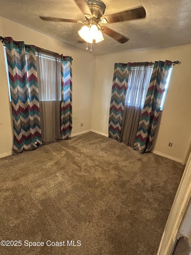 spare room featuring ceiling fan, carpet, and a textured ceiling