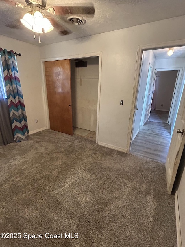 unfurnished bedroom with carpet, a textured ceiling, a closet, and ceiling fan