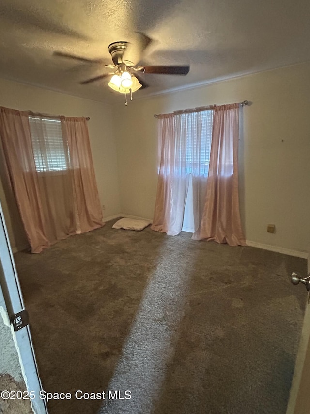 carpeted empty room featuring ceiling fan and a textured ceiling