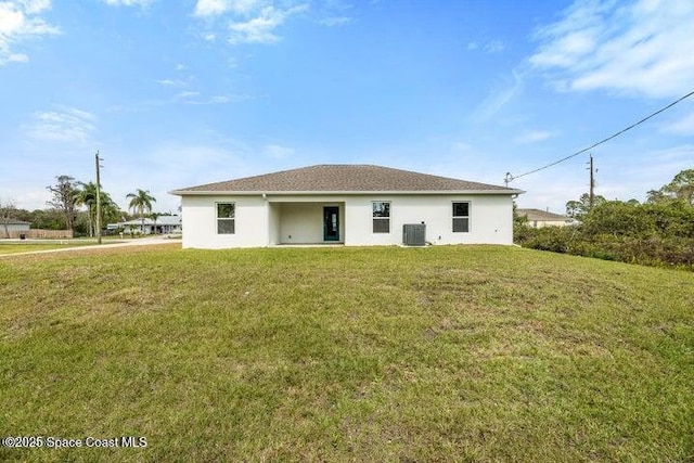 rear view of property featuring a yard and cooling unit