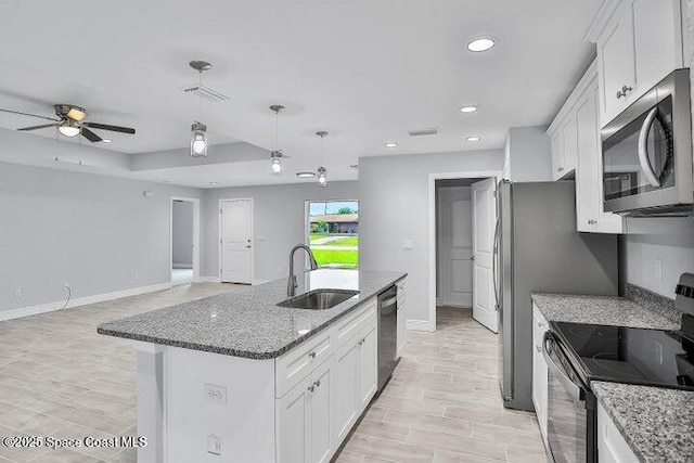 kitchen with white cabinets, sink, an island with sink, and stainless steel appliances