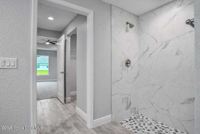 bathroom featuring tiled shower and ceiling fan